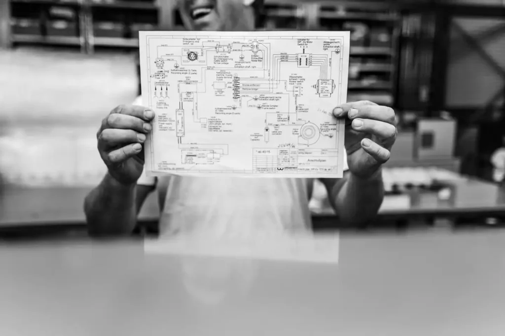 Mitarbeiter von Feinwerk Hamburg präsentiert einen technischen Schaltplan für die Fertigung